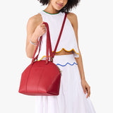 Cherry Large | Model holding a half circle crossbody bag with handles and removable crossbody strap 
