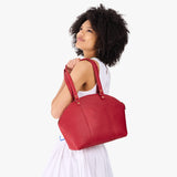 Cherry Large | Model holding a half circle crossbody bag with handles and removable crossbody strap 