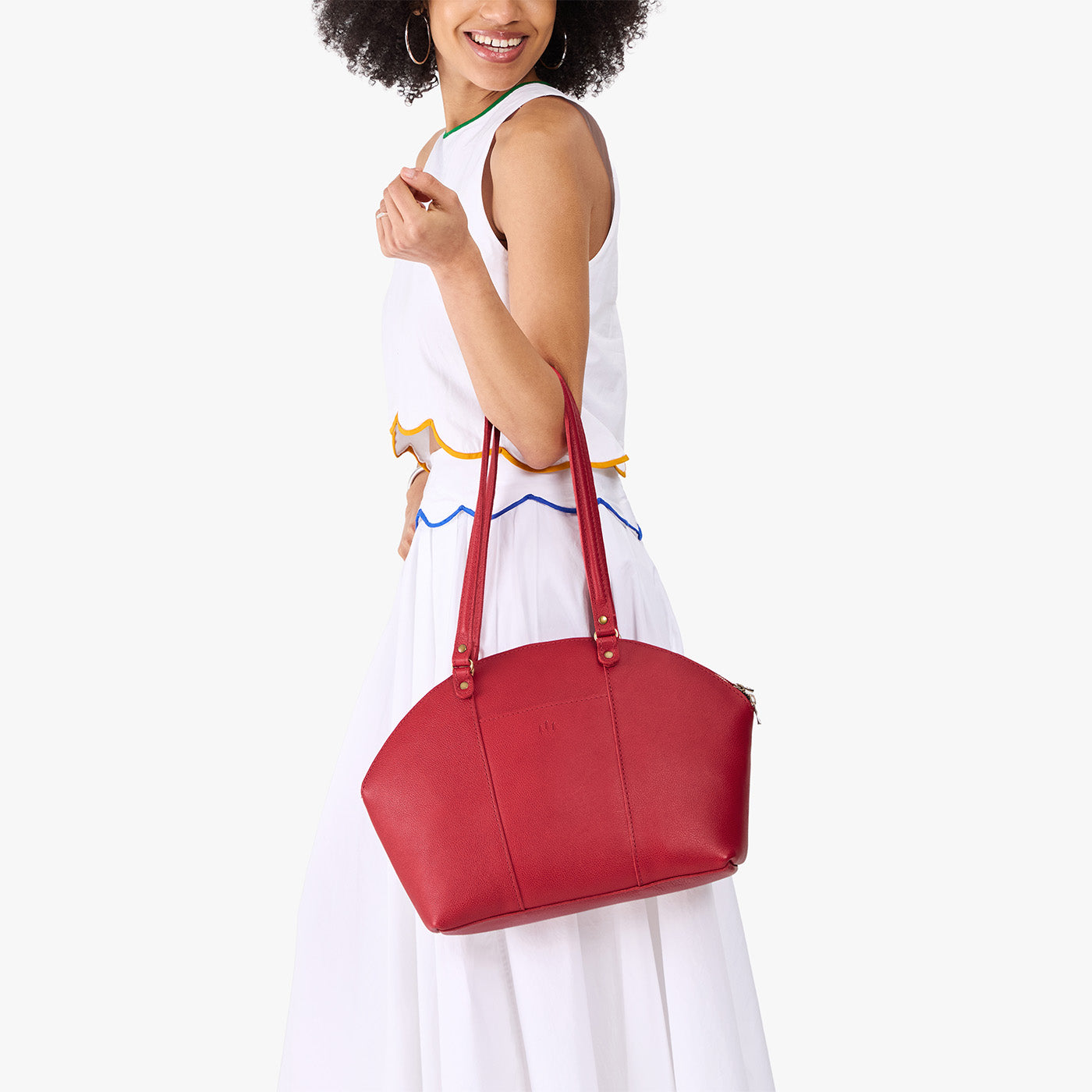 Cherry*Large | Model holding a half circle crossbody bag with handles and removable crossbody strap 
