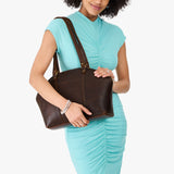Coldbrew Large | Model holding a half circle crossbody bag with handles and removable crossbody strap 