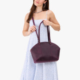 Larkspur Large | Model holding a half circle crossbody bag with handles and removable crossbody strap 