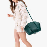 Sea Glass Large | Model holding a half circle crossbody bag with handles and removable crossbody strap