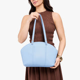Skyway Large | Model holding a half circle crossbody bag with handles and removable crossbody strap