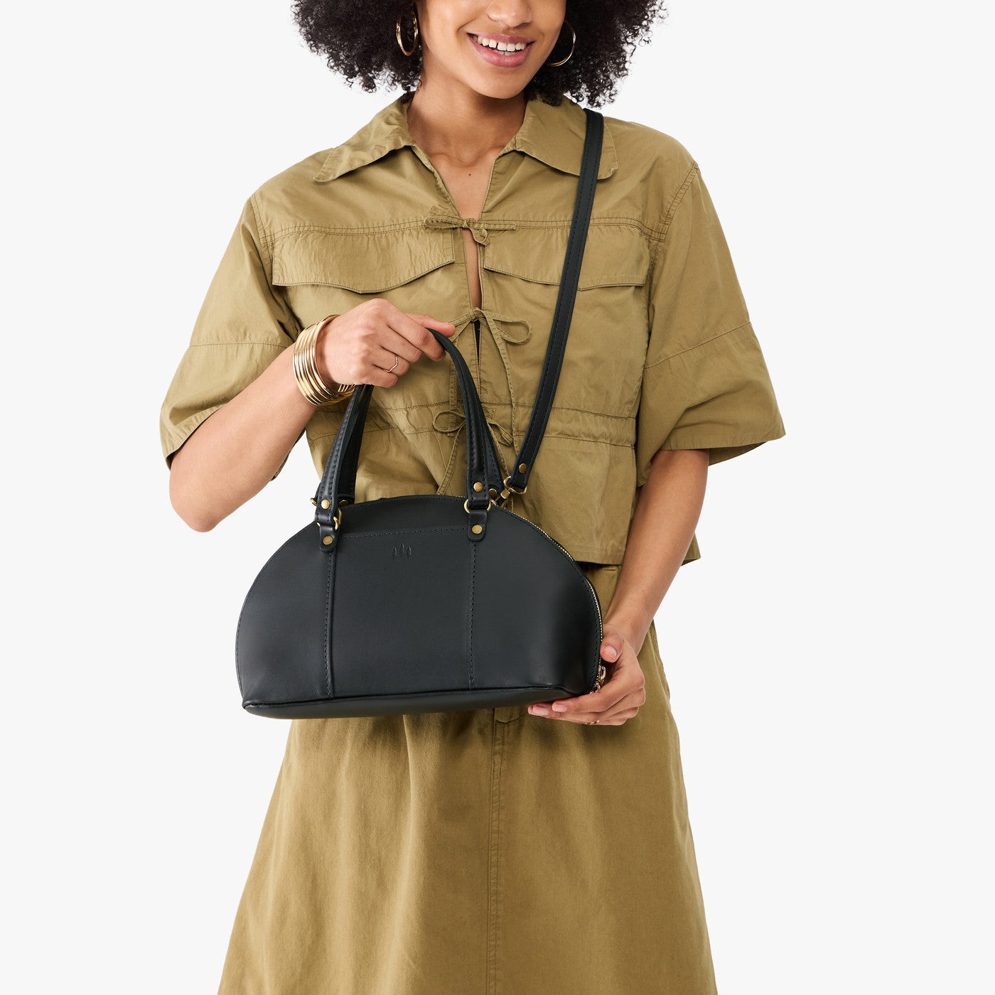 Black*Small | Model holding a half circle crossbody bag with handles and removable crossbody strap 