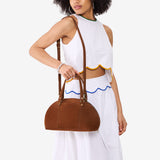 Wildwood Small | Model holding a half circle crossbody bag with handles and removable crossbody strap