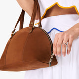 Wildwood Small | Model holding a half circle crossbody bag with handles and removable crossbody strap