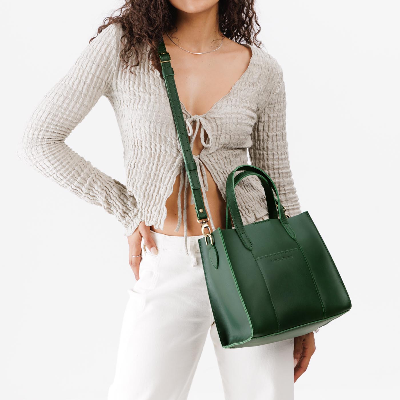 Aruba | Model wearing structured mid-size tote bag with overlapping panels and crossbody strap