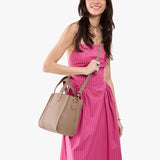Stone | Model wearing structured mid-size tote bag with overlapping panels and crossbody strap