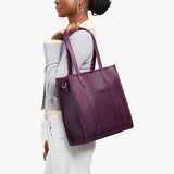 Larkspur North/South | Model holding structured large tote bag with overlapping panels and crossbody strap