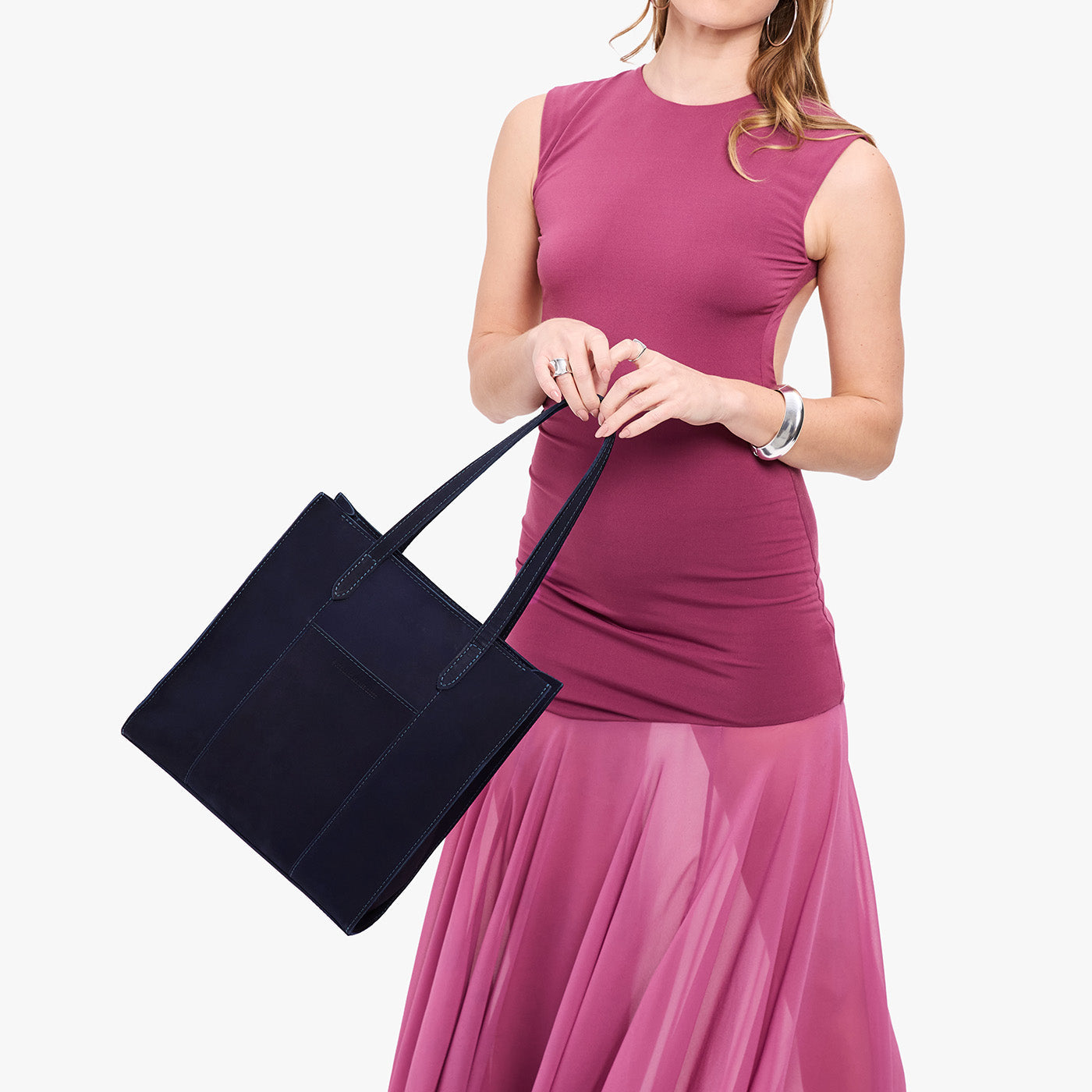 Velvet Blue*North/South | Model holding structured large tote bag with overlapping panels and crossbody strap