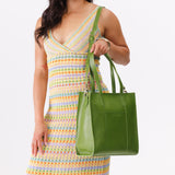 Green Apple North/South | Model holding structured large tote bag with overlapping panels and crossbody strap