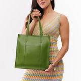 Green Apple North/South | Model holding structured large tote bag with overlapping panels and crossbody strap