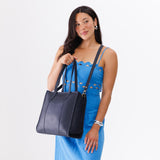 Night Owl North/South | Model wearing structured large tote bag with overlapping panels and crossbody strap