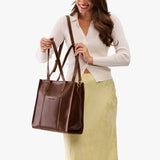 Chocolate Brown North/South | Model wearing structured large tote bag with overlapping panels and crossbody strap