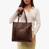 Chocolate Brown North/South | Model wearing structured large tote bag with overlapping panels and crossbody strap