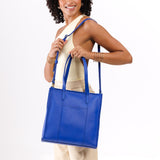 Astro Blue North/South | Model holding structured large tote bag with overlapping panels and crossbody strap