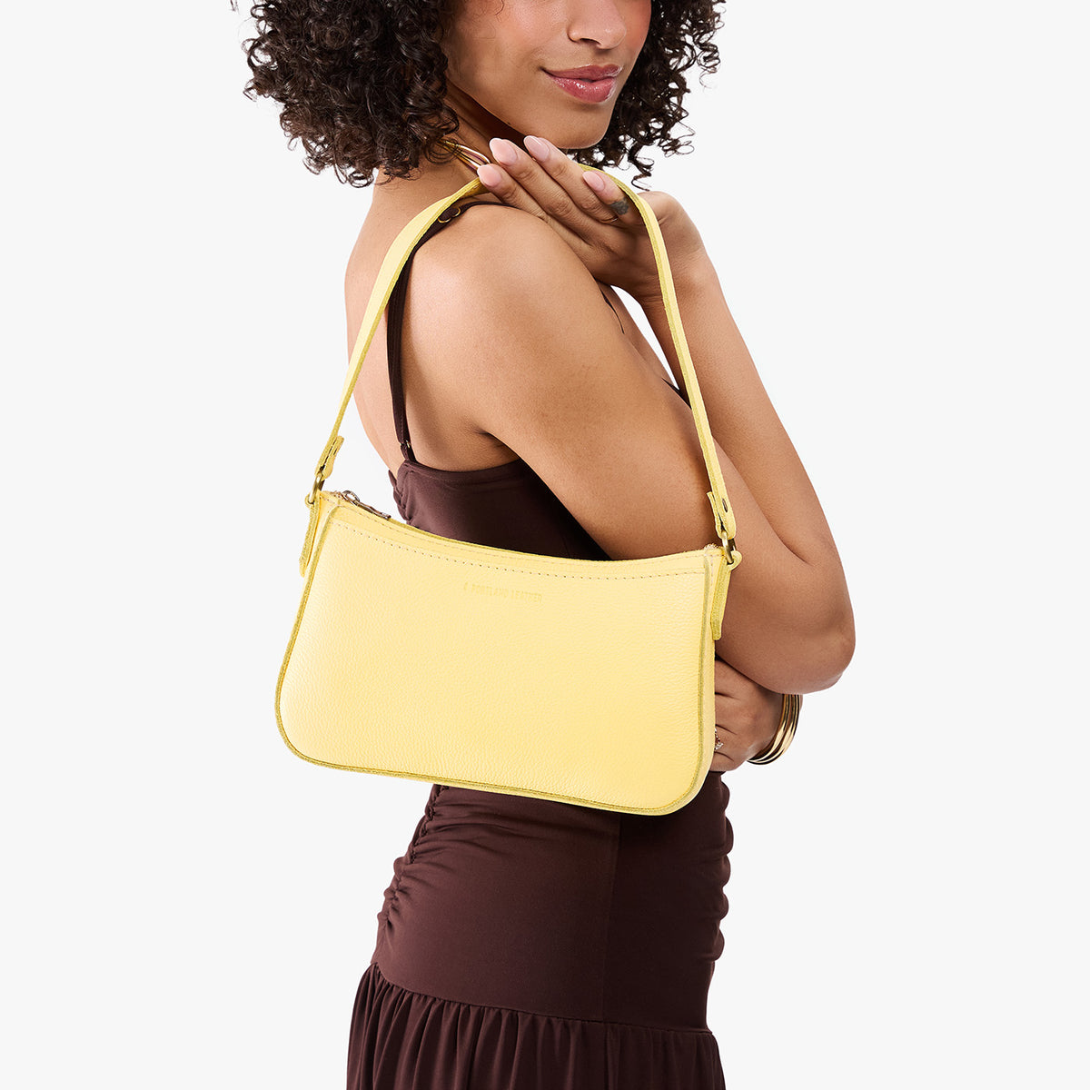 Butter Bliss | Model carrying petite bean shaped shoulder bag with a zipper closure