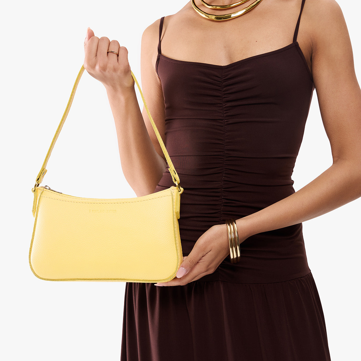Butter Bliss | Model holding petite bean shaped shoulder bag with a zipper closure
