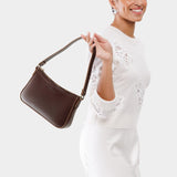 Chocolate Brown | Model holding petite bean shaped shoulder bag with a zipper closure