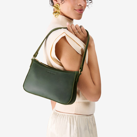 Evergreen | Model carrying petite bean shaped shoulder bag with a zipper closure