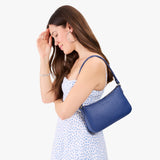 Molino Blue | Model carrying petite bean shaped shoulder bag with a zipper closure
