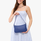 Molino Blue | Model carrying petite bean shaped shoulder bag with a zipper closure