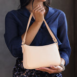 Moonflower | Model holding petite bean shaped shoulder bag with a zipper closure