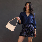 Moonflower | Model holding petite bean shaped shoulder bag with a zipper closure