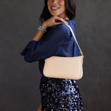 Moonflower | Model holding petite bean shaped shoulder bag with a zipper closure