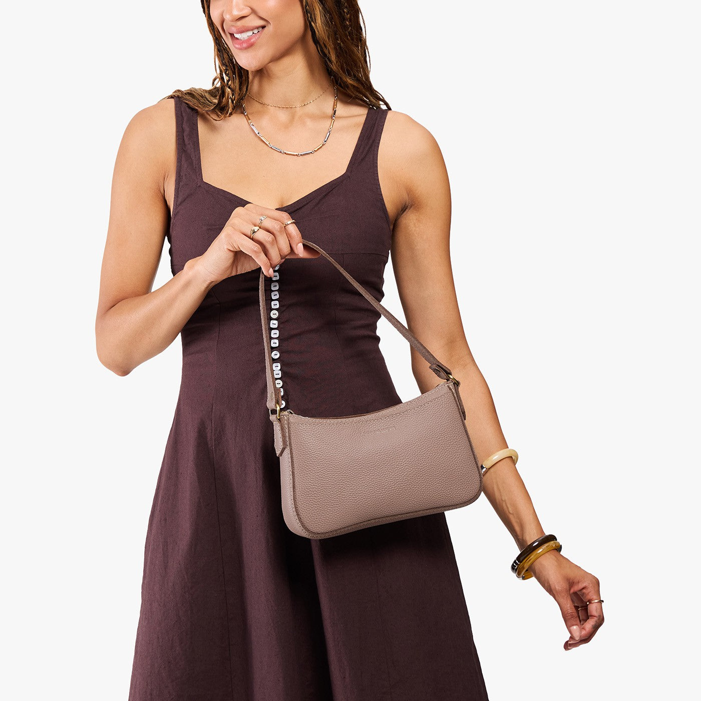 Sparrow*Small | Model carrying petite bean shaped shoulder bag with a zipper closure