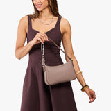 Sparrow Small | Model carrying petite bean shaped shoulder bag with a zipper closure