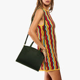 Evergreen Medium | Model carrying leather tote bag with handles, adjustable crossbody strap, and two back pockets