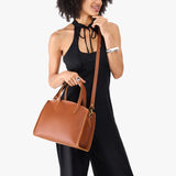 Honey Medium | Model carrying leather tote bag with handles, adjustable crossbody strap, and two back pockets