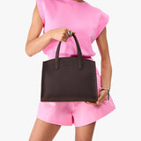 Moose Medium | Model carrying leather tote bag with handles, adjustable crossbody strap, and two back pockets