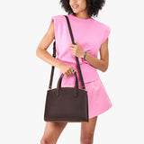 Moose Medium | Model carrying leather tote bag with handles, adjustable crossbody strap, and two back pockets