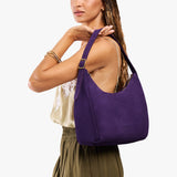 Imperial Medium | Model holding u-shaped, flat-bottomed leather shoulder bag with adjustable strap