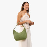 Laurel Medium | Model holding u-shaped, flat-bottomed leather shoulder bag with adjustable strap