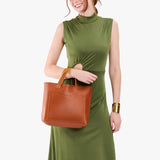 Sienna Classic | Model holding midsize crossbody tote with handles and a pocket