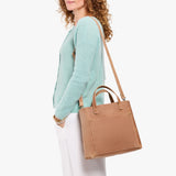 Rodeo | Model wearing a midsize crossbody tote with handles and a front pocket