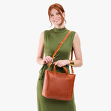 Sienna Zipper | Model holding midsize crossbody tote with handles and a pocket