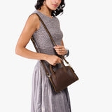 Coldbrew Mini | Model carrying small leather tote bag with handles, adjustable crossbody strap, and one back pocket