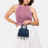 Deep Water Mini | Model carrying small leather tote bag with handles, adjustable crossbody strap, and one back pocket