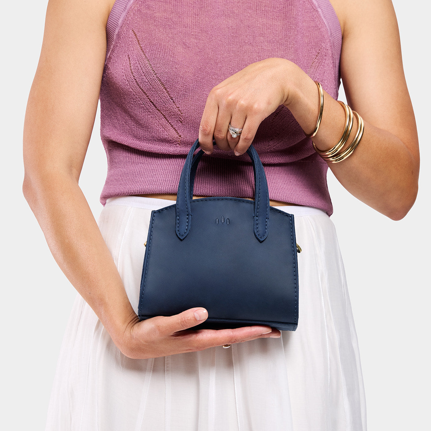 Deep Water*Mini | Model holdng small leather tote bag with handles, adjustable crossbody strap, and one back pocket