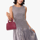 Orchid Mini | Model carrying small leather tote bag with handles, adjustable crossbody strap, and one back pocket