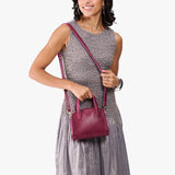 Orchid Mini | Model carrying small leather tote bag with handles, adjustable crossbody strap, and one back pocket