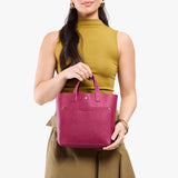Cosmo Classic | Model holding crossbody tote bag with snap closure and front pocket