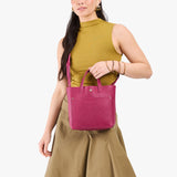 Cosmo Classic | Model holding crossbody tote bag with snap closure and front pocket