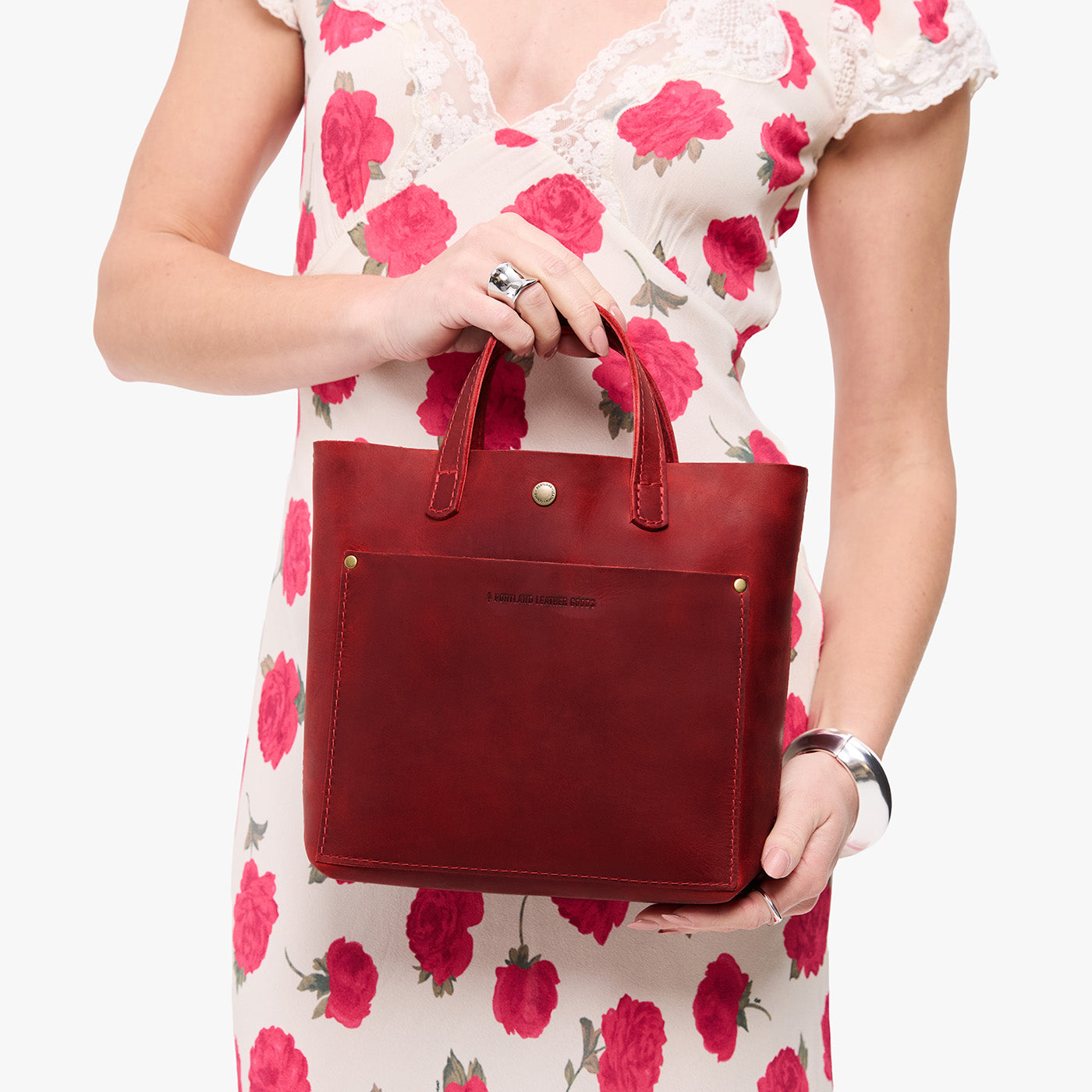 Phoenix*Classic | Model holding crossbody tote bag with snap closure and front pocket