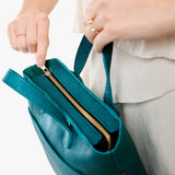 Aquarius Zipper | Model holding crossbody tote bag with zipper closure and front pocket