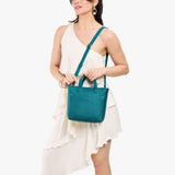 Aquarius Zipper | Model holding crossbody tote bag with zipper closure and front pocket
